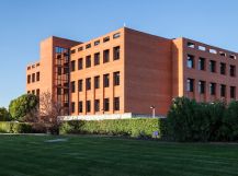 Fachada de una universidad en España con áreas verdes