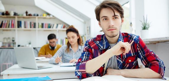Joven estudiante en una universidad en España tomando notas en clase