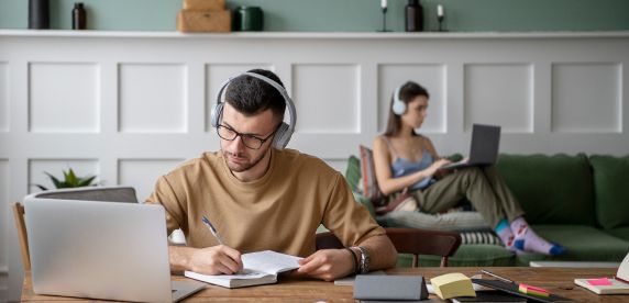 Joven estudiando en línea con auriculares en un entorno moderno