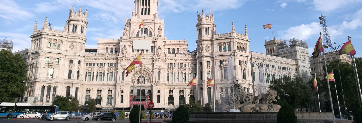 Edificio emblemático de una universidad en Madrid con banderas de España