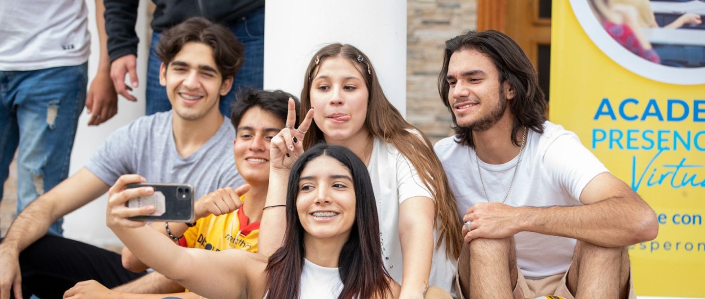 Grupo de jóvenes estudiantes de Esperon sonriendo y tomándose una selfie en un evento universitario