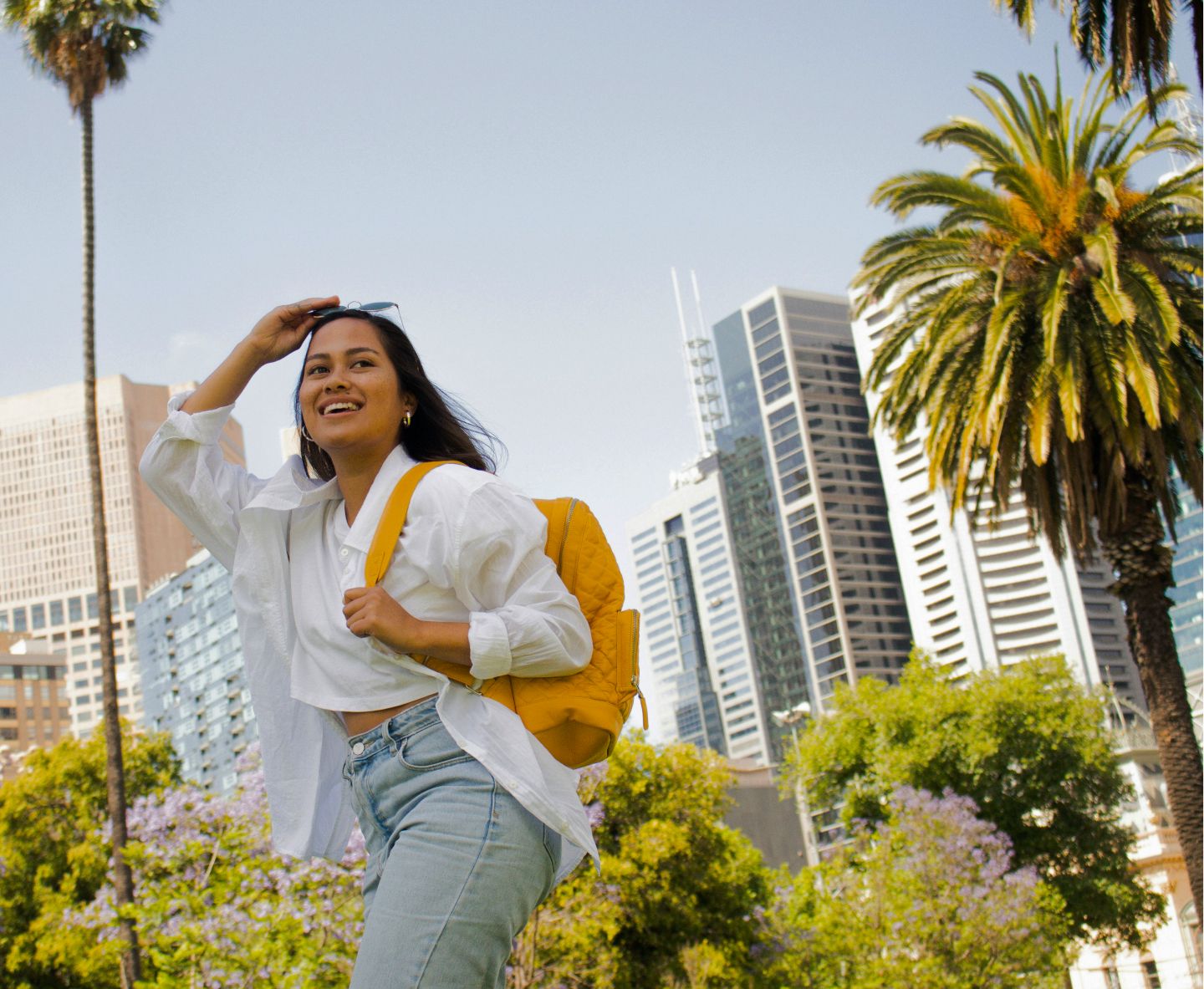 Joven disfrutando de la ciudad con su mochila y gafas de sol